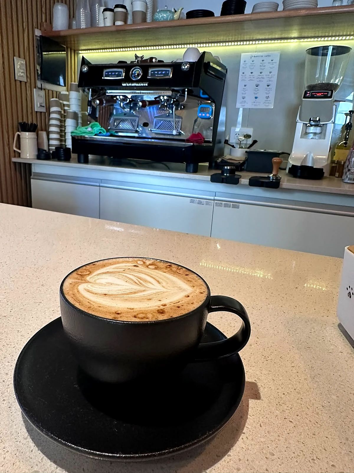 Flat white con latte art en la barra de La Esquinita